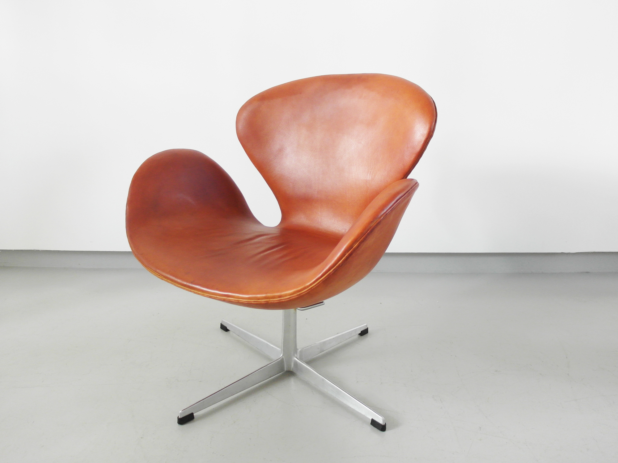 Early edition Arne Jacobsen Swan chair in original cognac